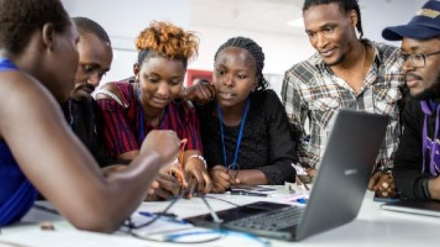 Eine Gruppe von Menschen, die auf einen Computer schauen.