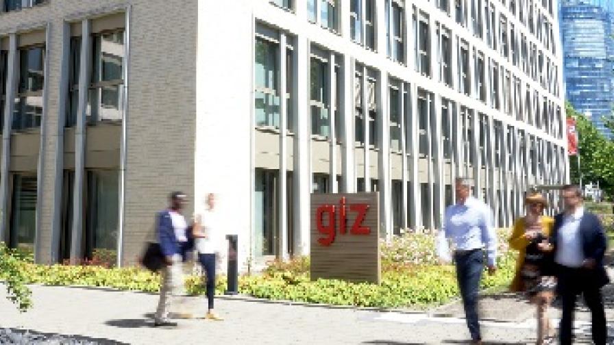 People in motion in front of the GIZ building