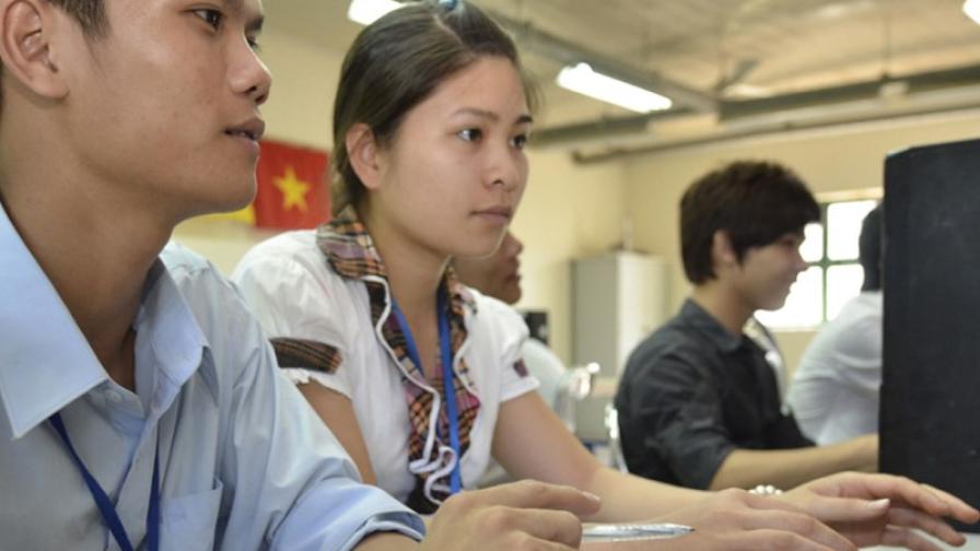 In Vietnam, young professionals sit in front of computers.