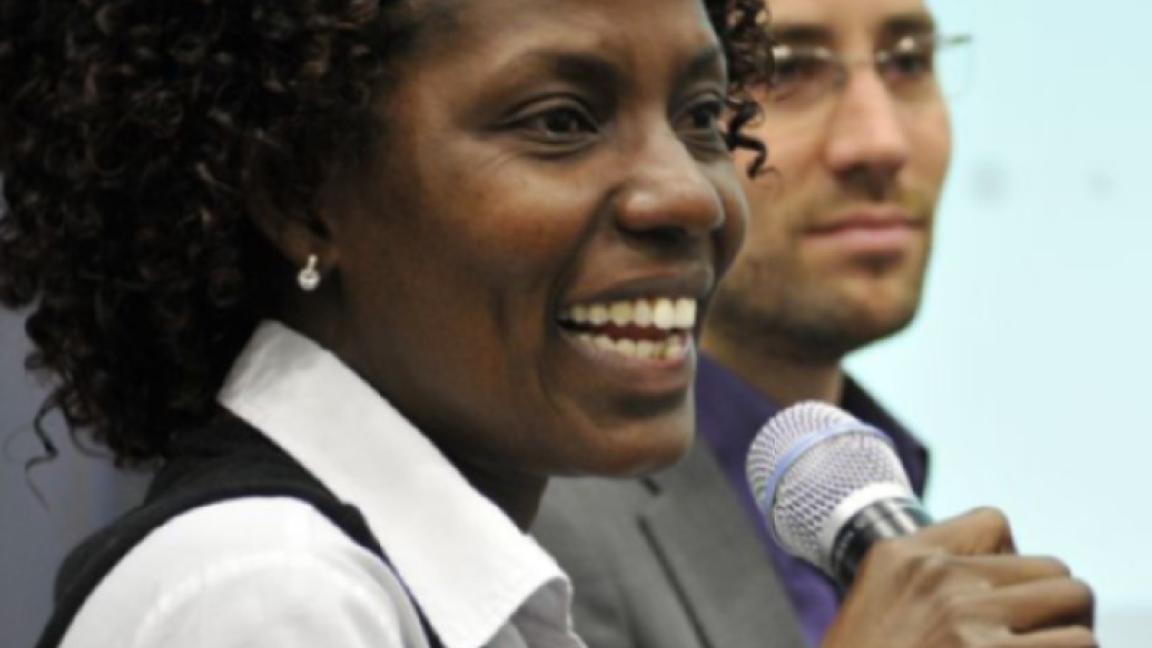 Eine Frau lächelt, während sie ein Mikrofon hält.