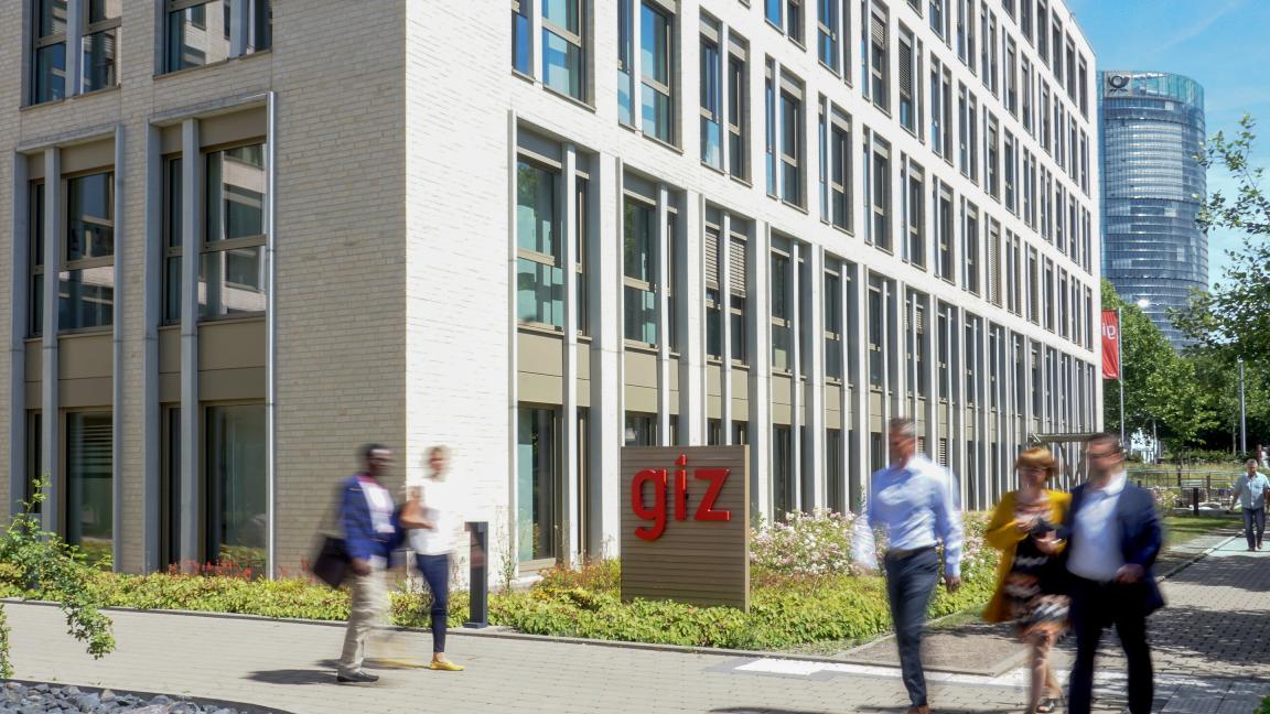 Menschen in Bewegung vor dem Gebäude der GIZ