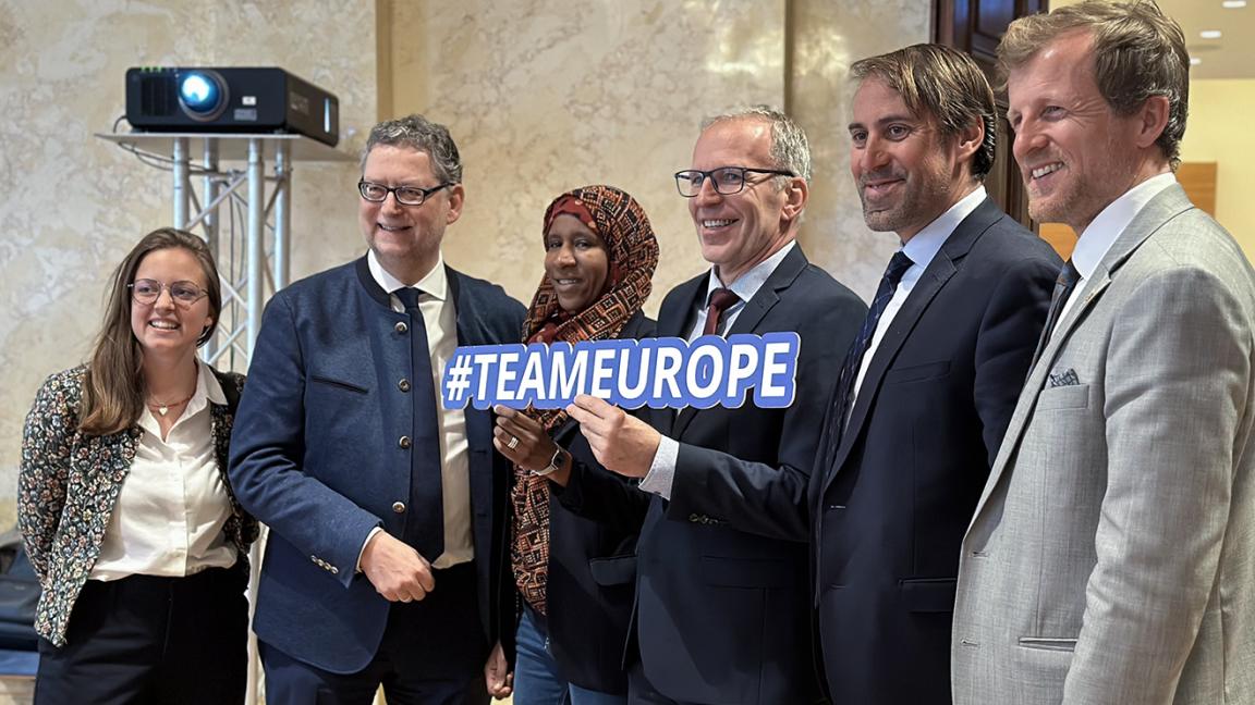 Six people posing together for a group photo, one person in the center holding a sign reading "#TEAMEUROPE".
