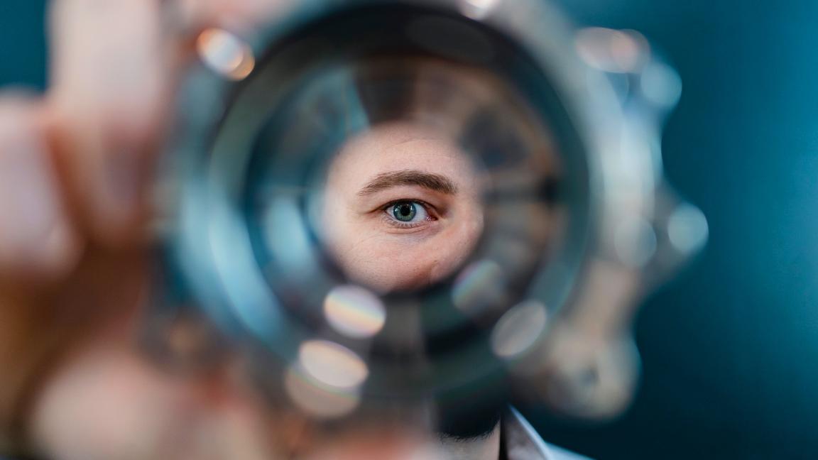 Mann blickt durch ein Werkstück