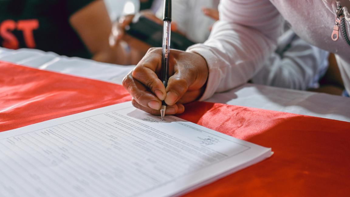 Nahaufnahme einer Hand, die ein Dokument unterschreibt