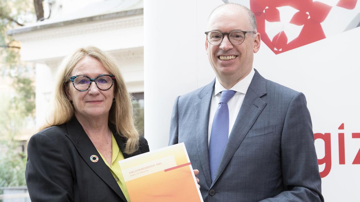 Zwei Personen präsentieren einen Bericht. 