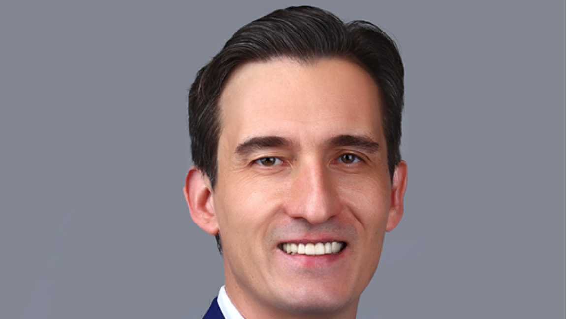 A photo of middle-aged man with a white shirt and a blue jacket