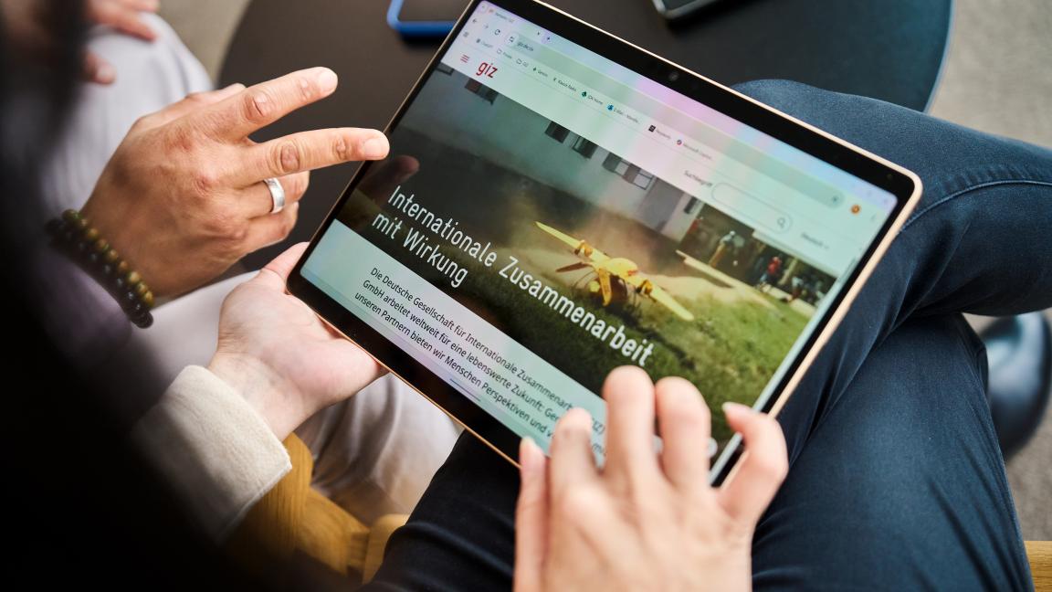 Nahaufnahme eines Tablets, auf dem eine Website mit der Überschrift „Internationale Zusammenarbeit mit Wirkung“ geöffnet ist.