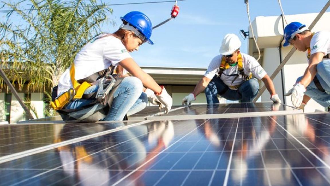 Technicians installing solar panels on a rooftop in Brazil. 
