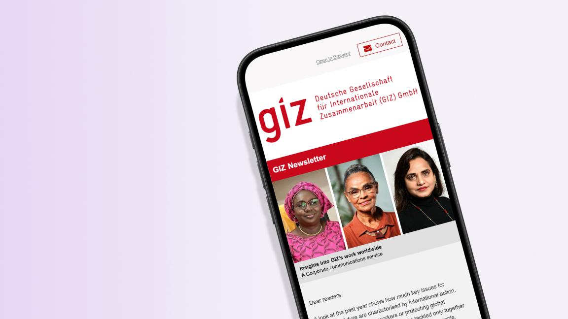Smartphone mockup displaying the GIZ newsletter featuring the logo of Deutsche Gesellschaft für Internationale Zusammenarbeit and portrait photos of three women as the header image.