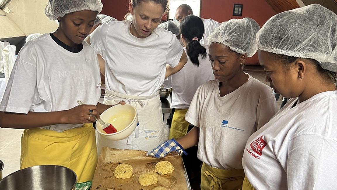 Bäckermeisterin Sarah Braun steht an einem Tisch mit drei angehenden Bäckerinnen aus Madagaskar.