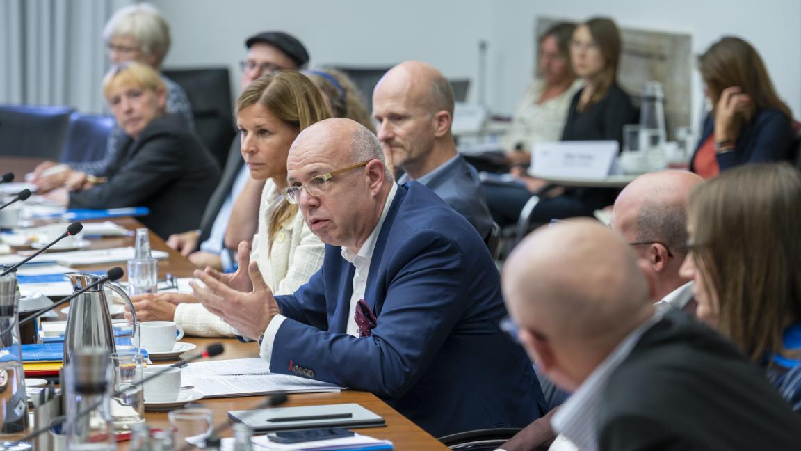 Unternehmensvertreter*innen sitzen an einem Tisch und diskutieren