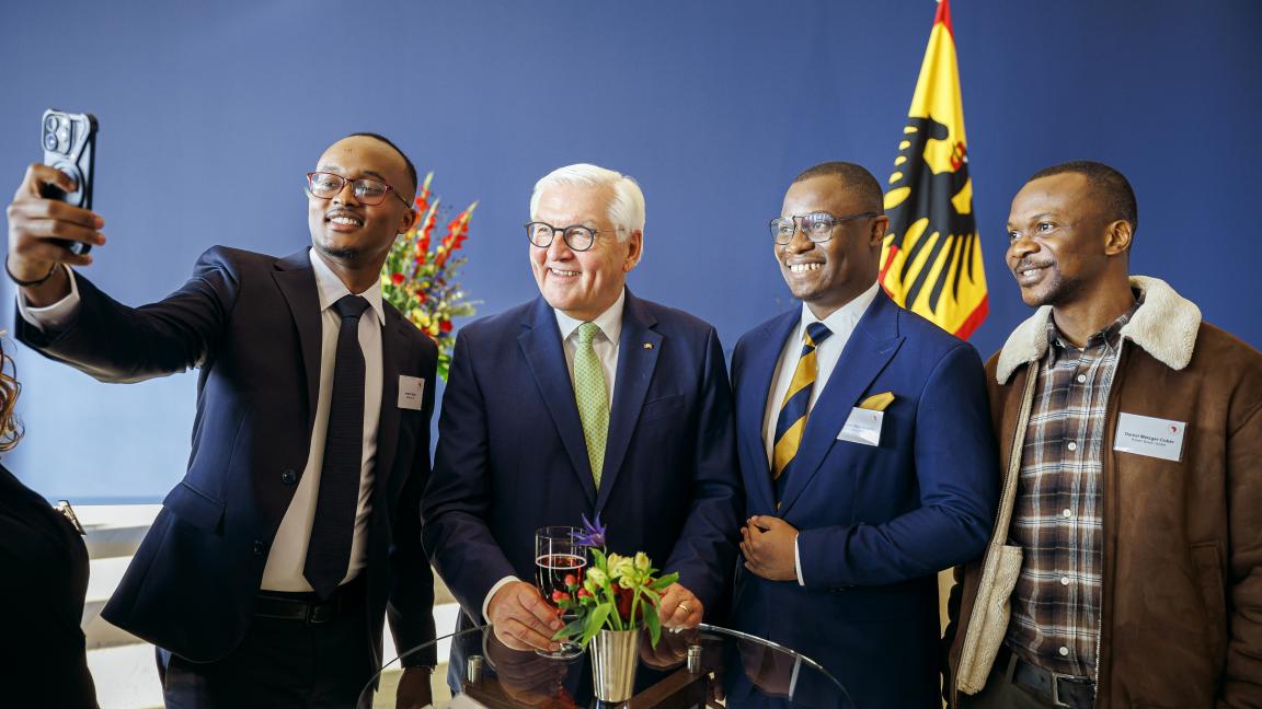 Drei der Stipendiaten machen ein Selfie mit Bundespräsident Frank-Walter Steinmeier im Schloss Bellevue. Alle grinsen ins Smartphone.