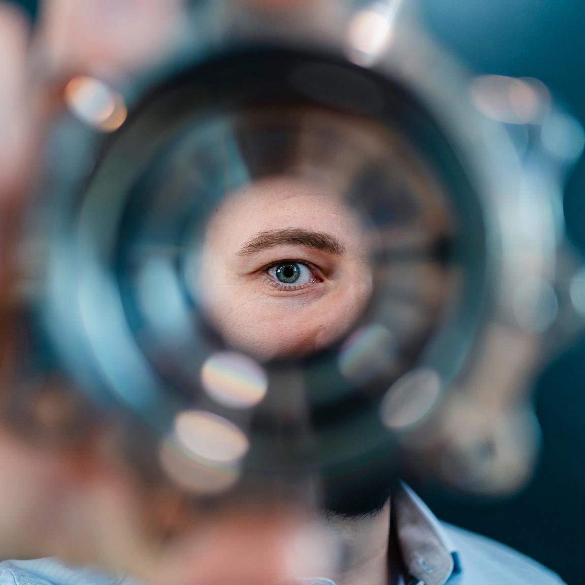 Mann blickt durch ein Werkstück