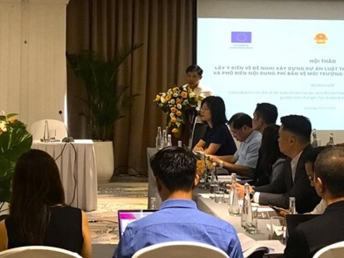 Group of people sitting at tables listening to a presentation