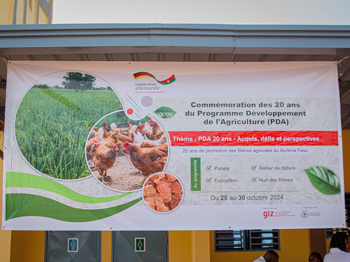 Zum zwanzigjährigen Bestehen eines Projektes in Burkina Faso ist ein Plakat aufgestellt.