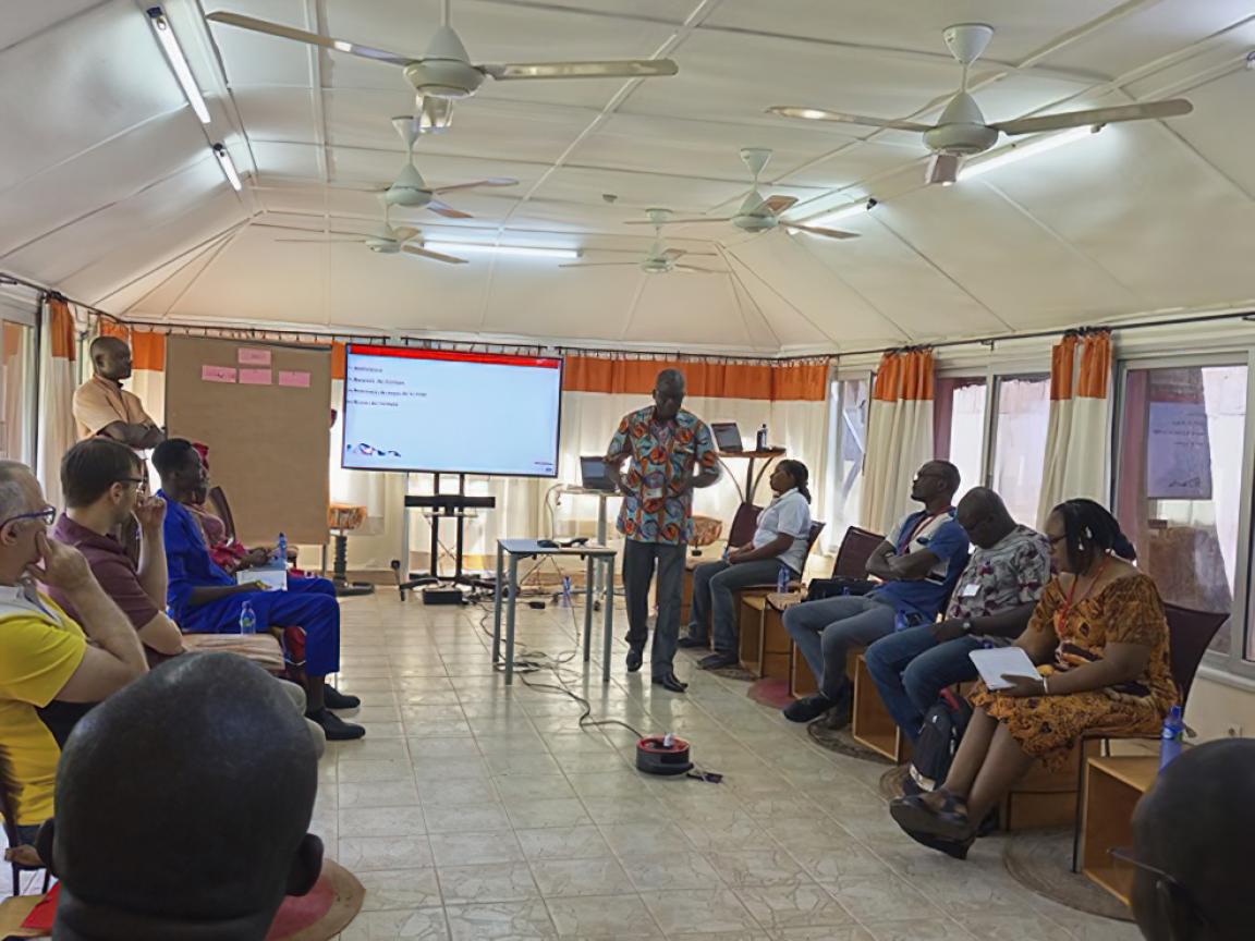 Ein Mann hält in der Mitte eines Konferenzraums einen Vortrag für seine Zuhörer.