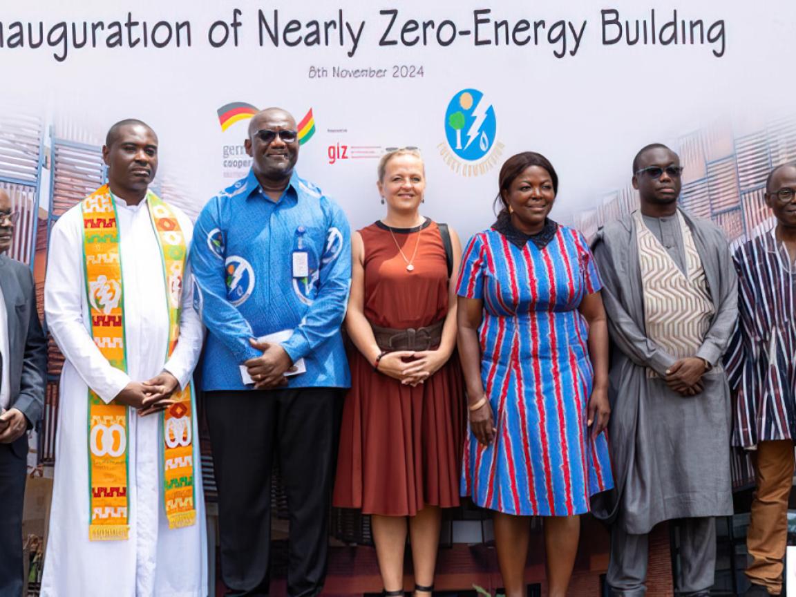 Sieben Menschen posieren bei der Eröffnung eines "Nearly Zero-Energy Building".