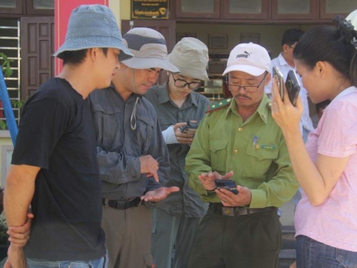 Man showing something on his phone to 3 coworkers