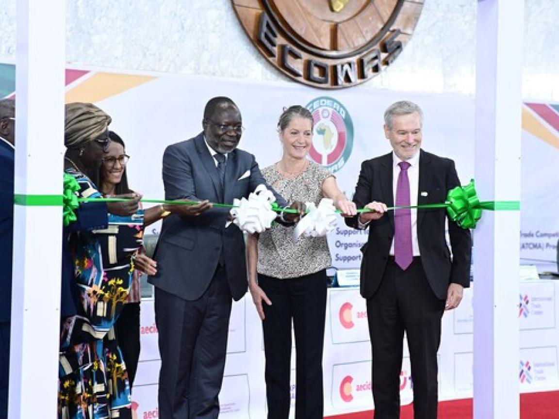 Personen schneiden gemeinsam ein grünes Band durch