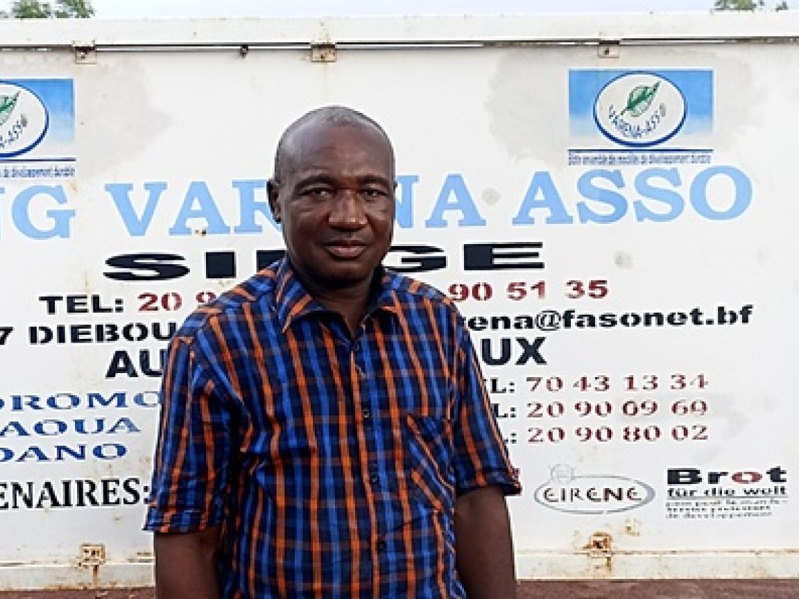Sanon, Koordinator von VARENA ASSO, vor dem Straßenschild von  VARENA ASSO.