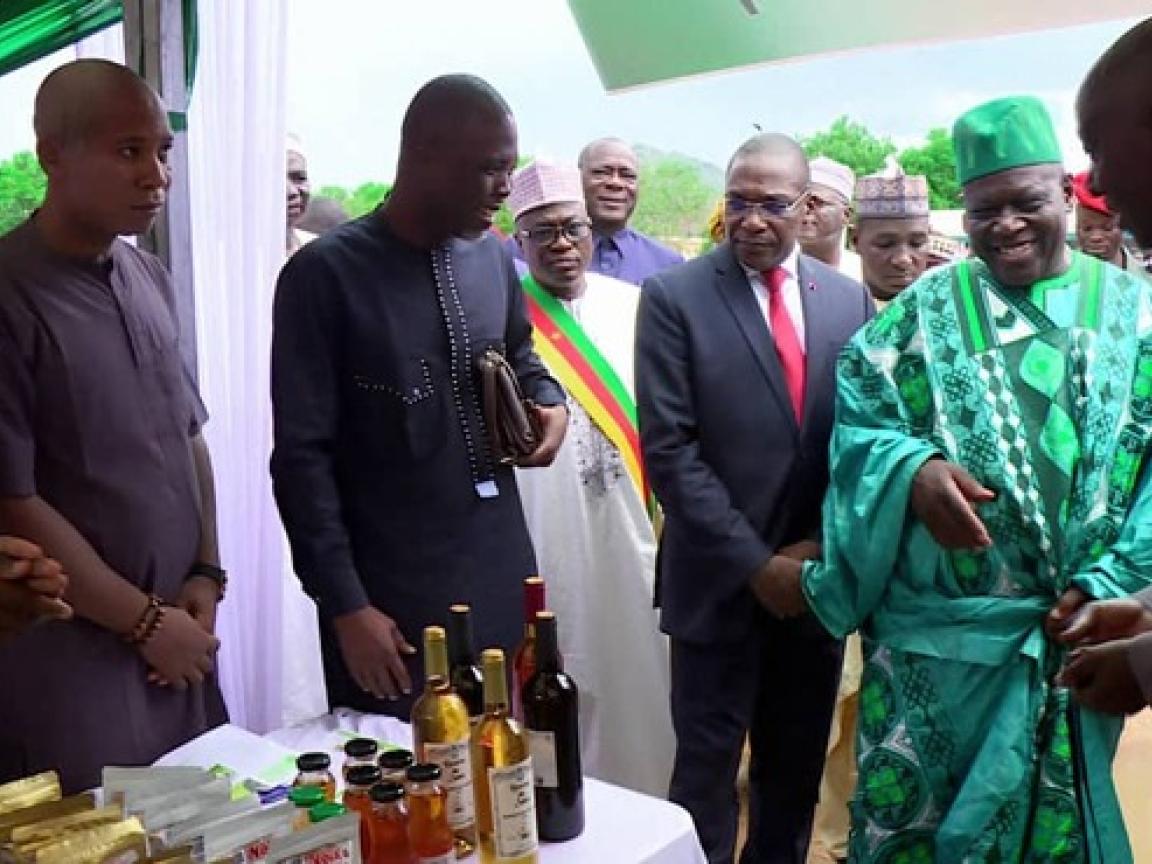 Viele Personen stehen um einen Tisch herum auf dem Flaschen stehen