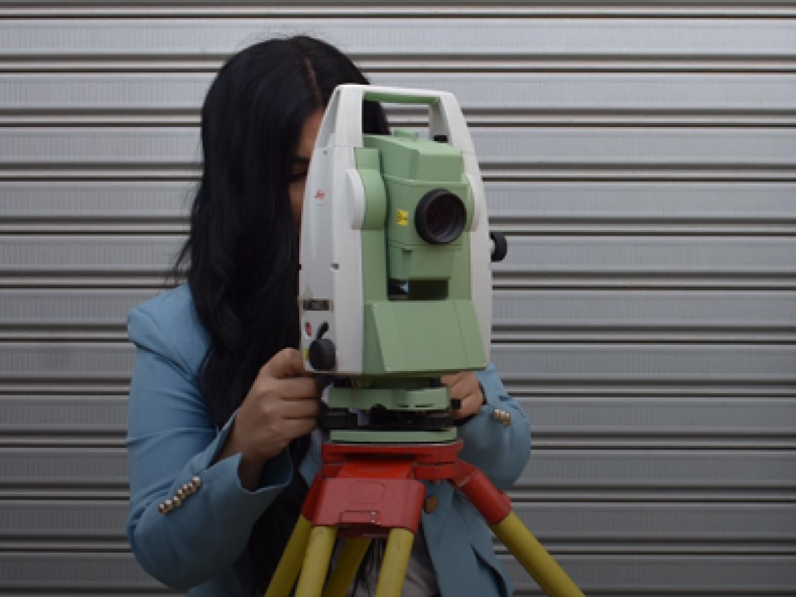 A woman operating a surveying instrument