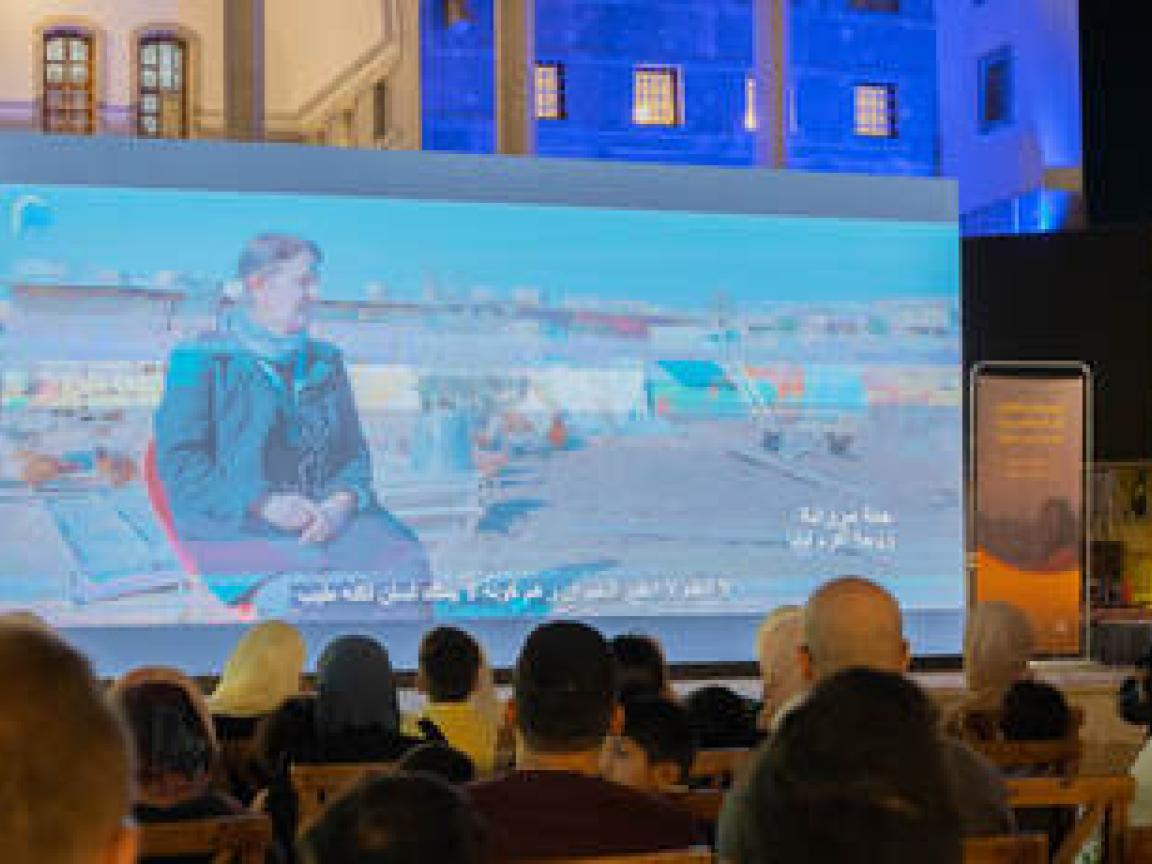 People watching a movie at an open air cinema