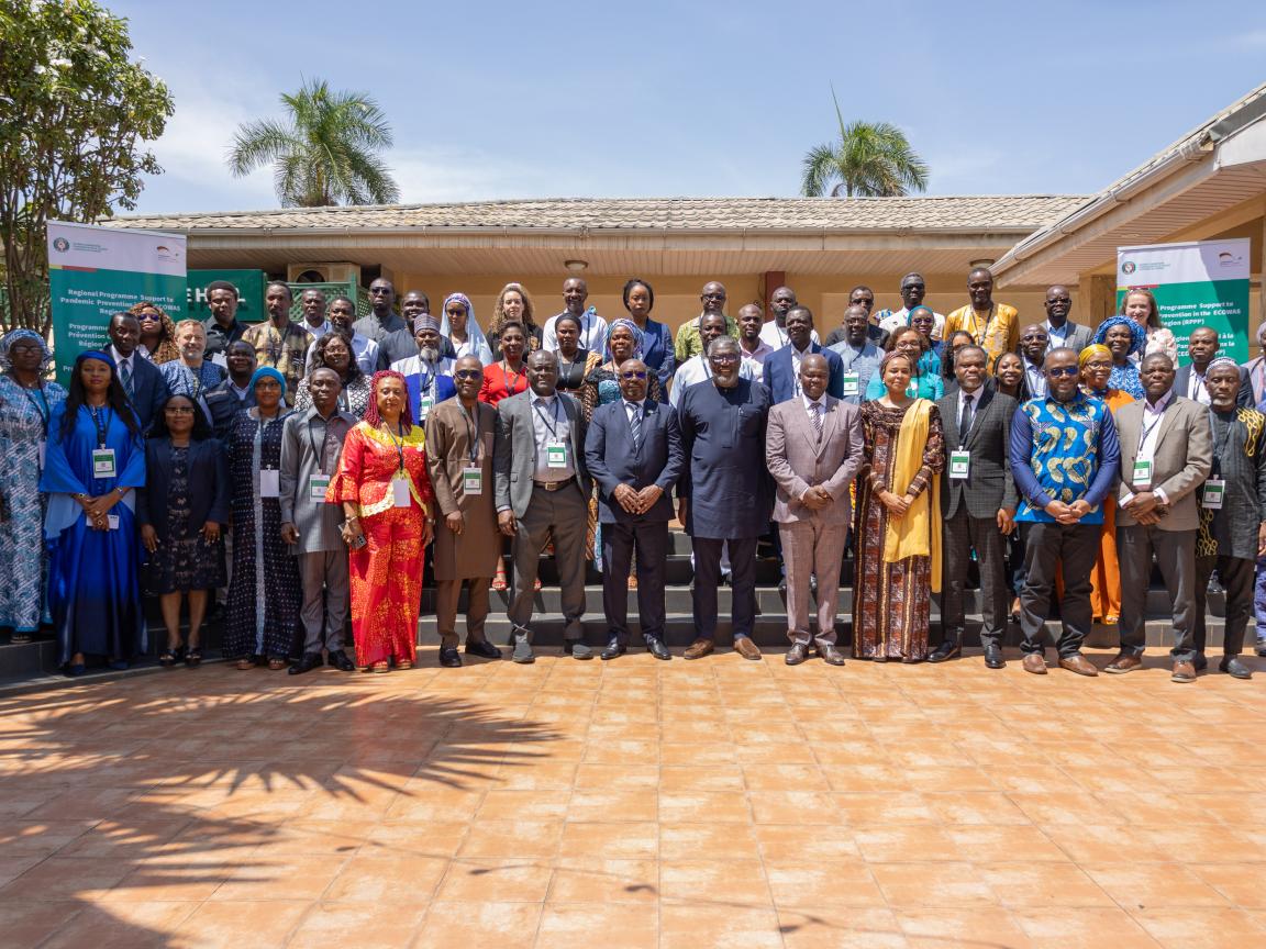 Ein Gruppenfoto in einem Hof vor einem großen Haus.