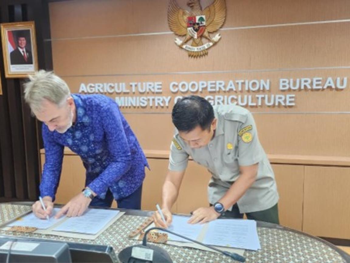 Zwei Männer unterzeichnen ein Dokument im Landwirtschaftsministerium.