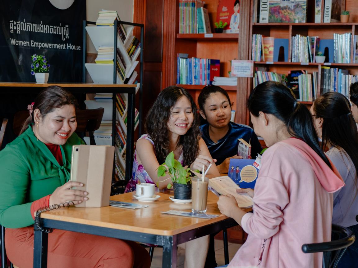 Five young women are sitting in a cozy room in a Women Empowerment House.