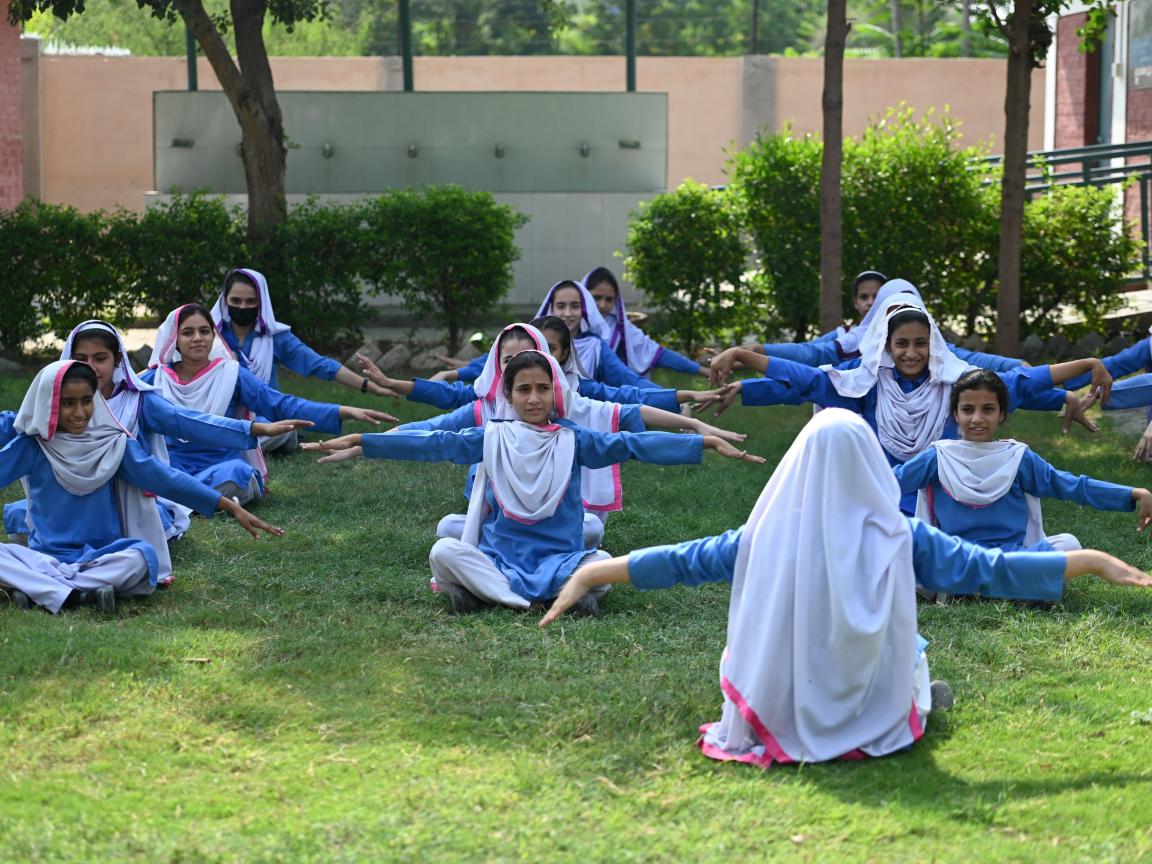  A group of female students in school uniform participating in an outdoor school activity.