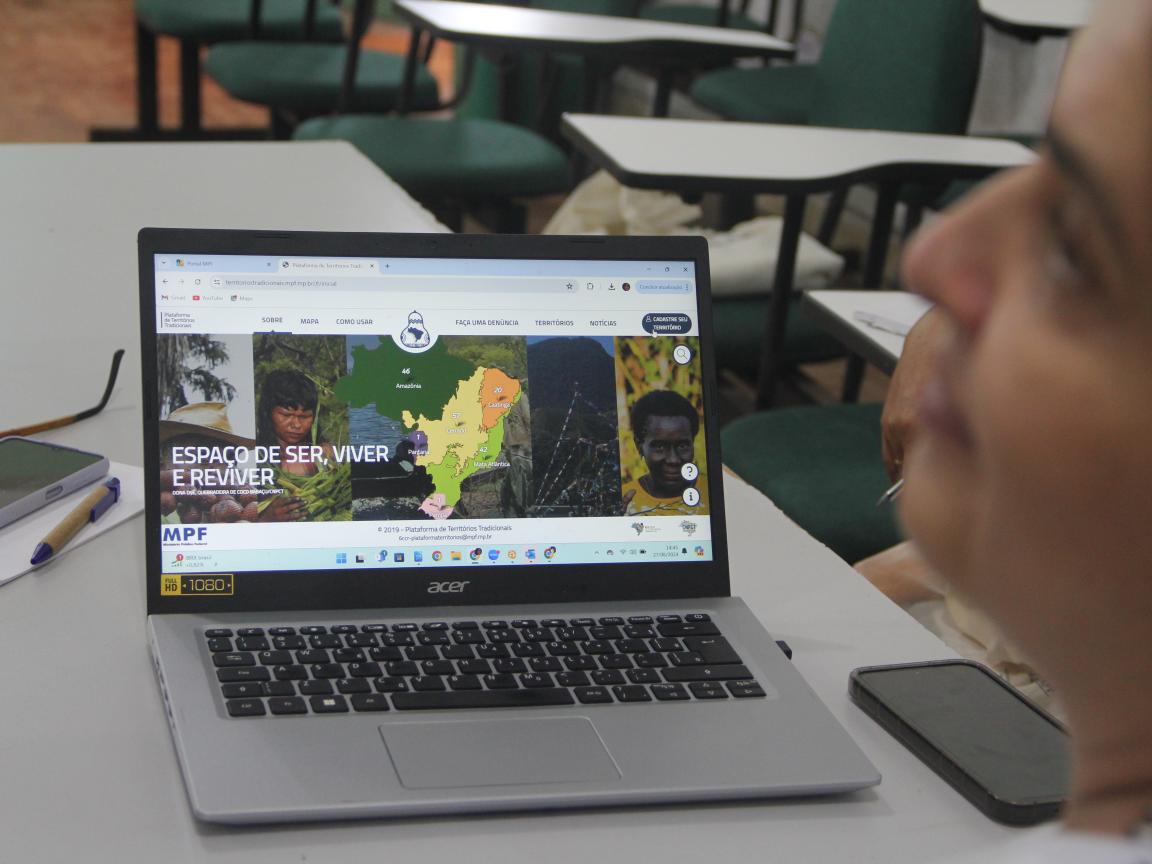 uma mulher está com a tela de computador aberta na plataforma de territórios tradicionais 