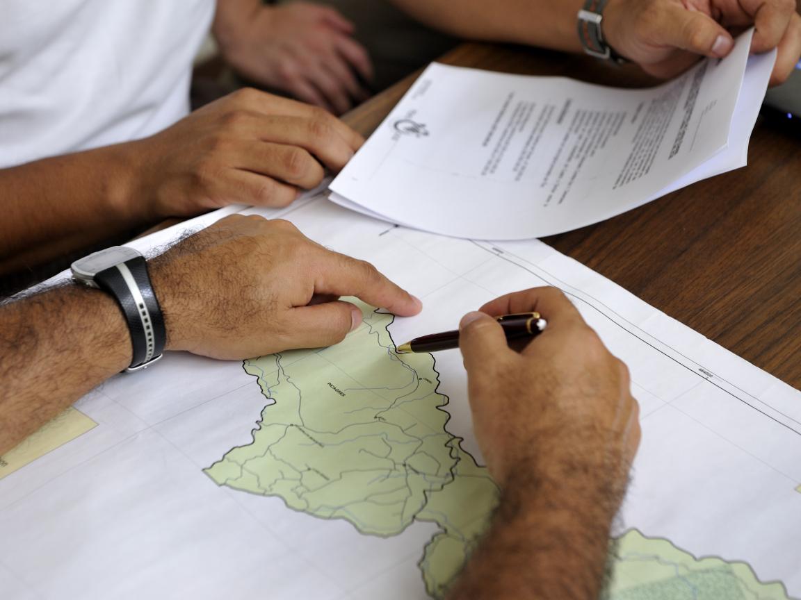 Personas señalas un punto en un mapa