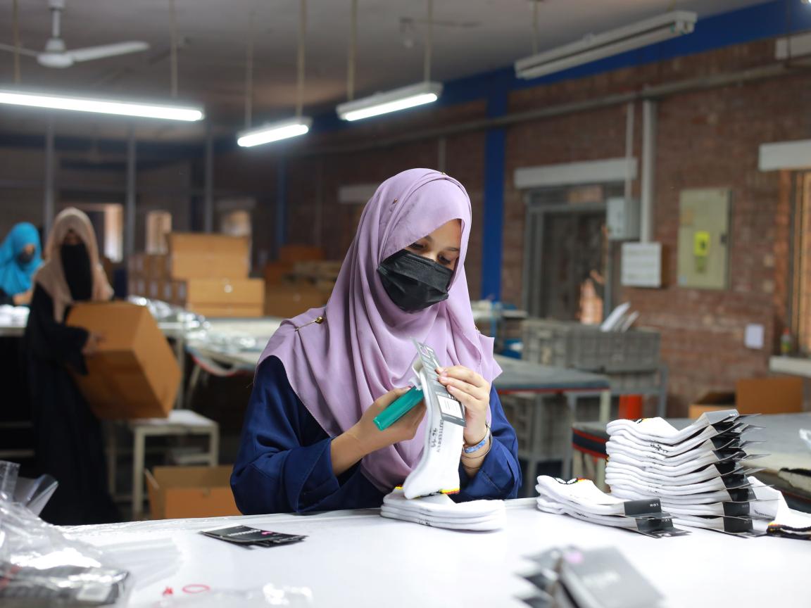 A woman trainee is shown packing a pair of socks