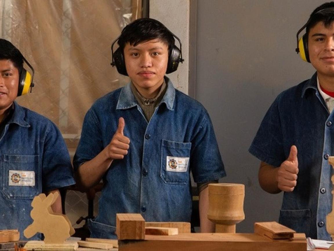 A group of men wearing headphones and giving a thumbs up.
