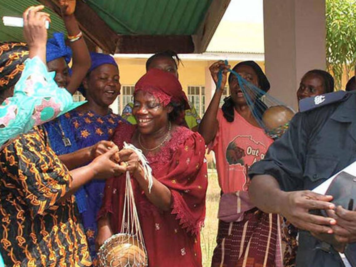 Ein Polizeibeamter ist von Frauen umringt.