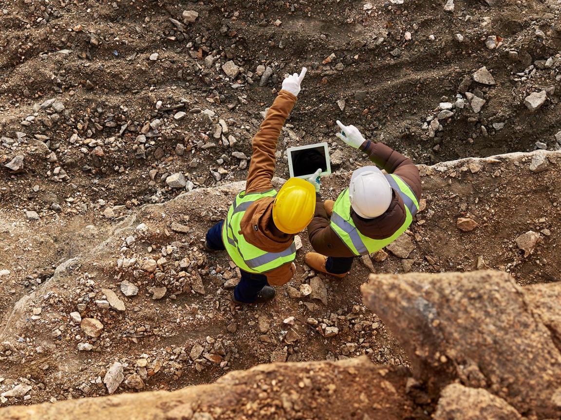 Zwei Bauarbeiter mit Helmen führen eine Inspektion durch
