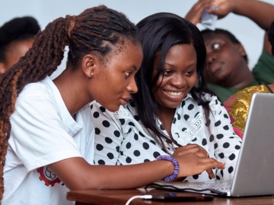 Junge Frauen sitzen vor einem Laptop