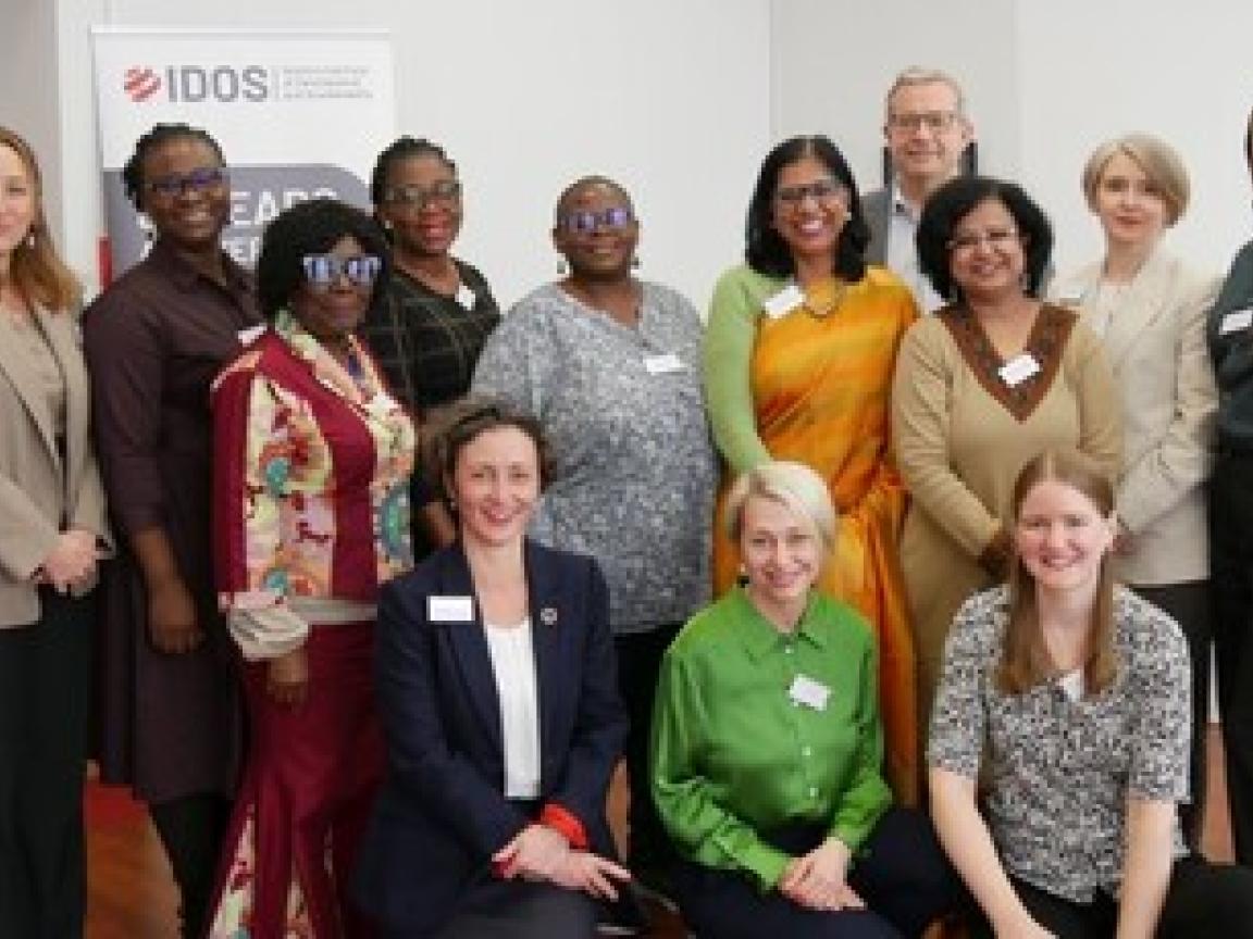 A group of people, most of them women, smile at the camera.