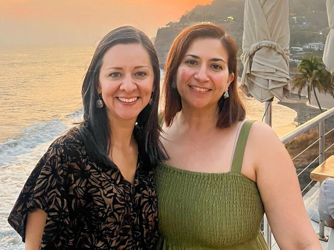 Maria Escobar stands in front of a sunset