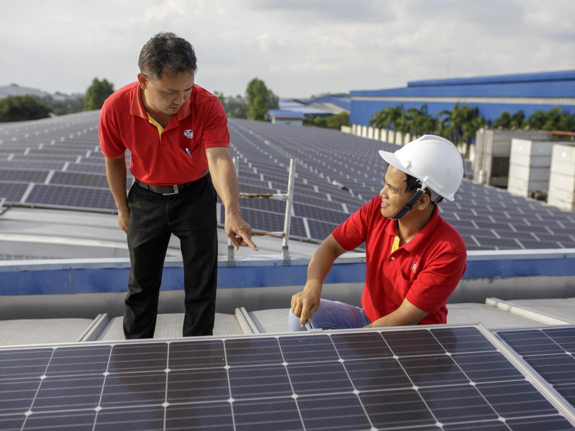 Zwei Solartechniker arbeiten an PV-Panelen.