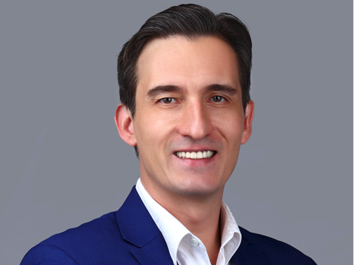 A photo of middle-aged man with a white shirt and a blue jacket