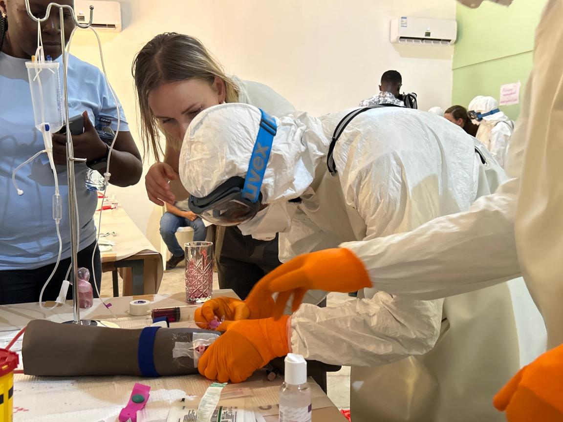 A healthcare worker learns how to treat an Ebola patient while wearing protective gear.