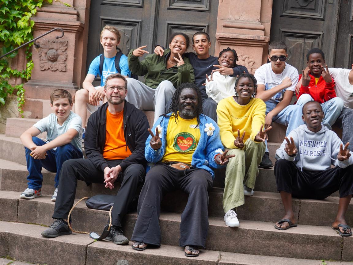A group of teenagers is sitting on some steps