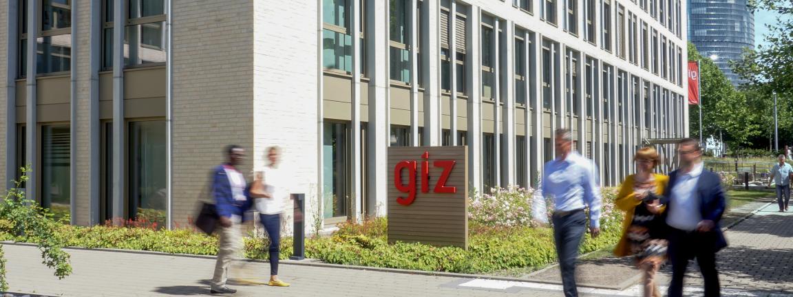 Menschen in Bewegung vor dem Gebäude der GIZ