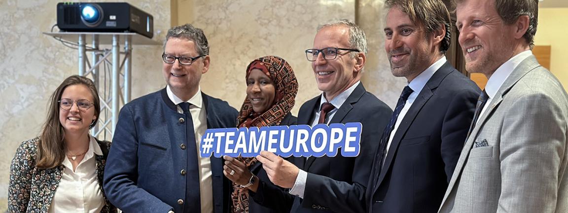 Sechs Personen posieren gemeinsam für ein Gruppenfoto, eine Person in der Mitte hält ein Schild mit der Aufschrift "#TEAMEUROPE".