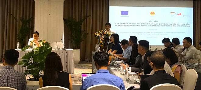 Group of people sitting at tables listening to a presentation