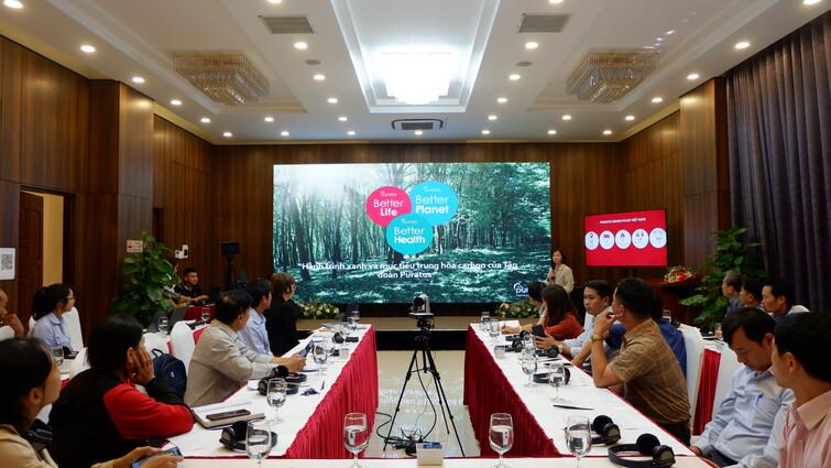 Group of people sitting at tables listening to a presentation