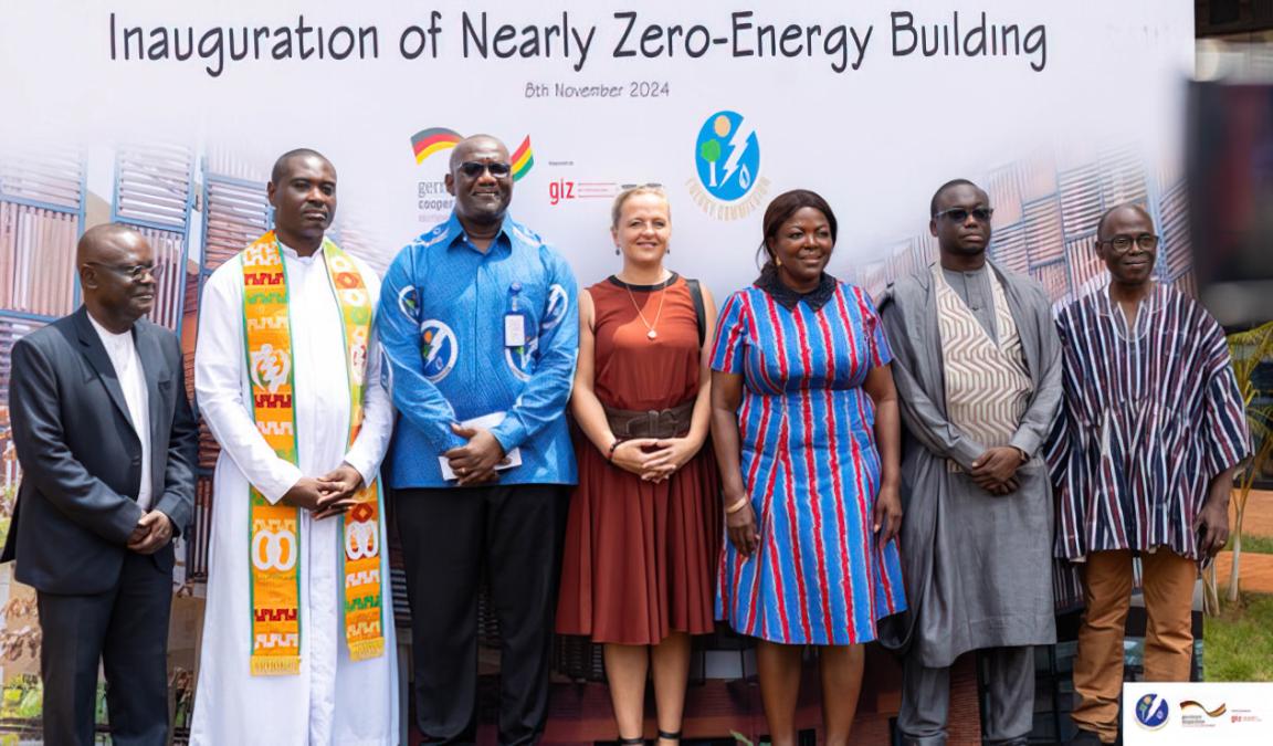 Sieben Menschen posieren bei der Eröffnung eines "Nearly Zero-Energy Building".