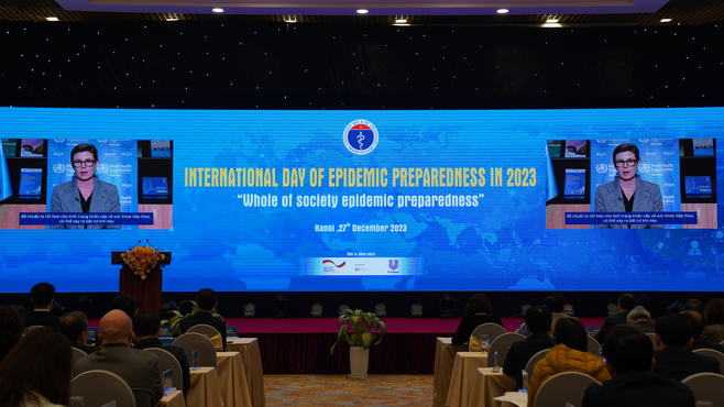 People sitting at tables listening to a woman talk: International day of epidemic preparedness in 2023